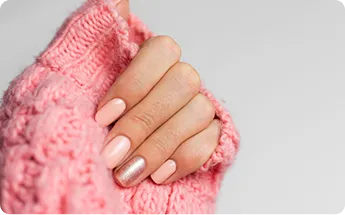 pretty nude color manicure one finger shiny golden knitted pink wool pullover background
